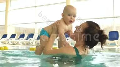 <strong>妈妈</strong>和<strong>宝宝</strong>在游泳池里玩得开心。 女人<strong>亲吻</strong>拥抱她的孩子。 母亲节